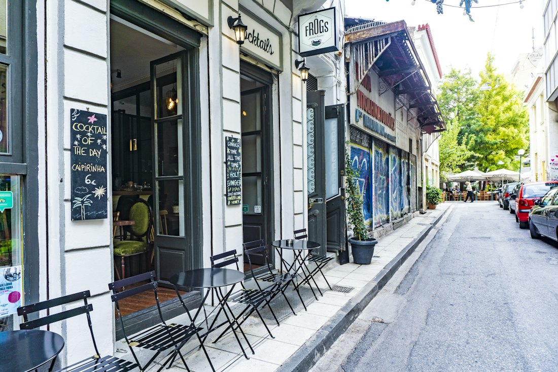 Cafe tables on a quiet tree-lined street in Athens